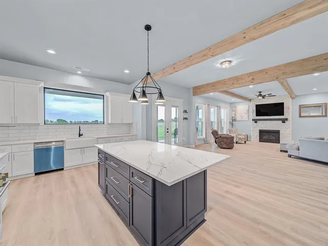 a kitchen with stainless steel appliances granite countertop a sink stove and wooden floor