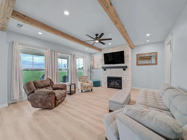 a living room with furniture a fireplace and a flat screen tv