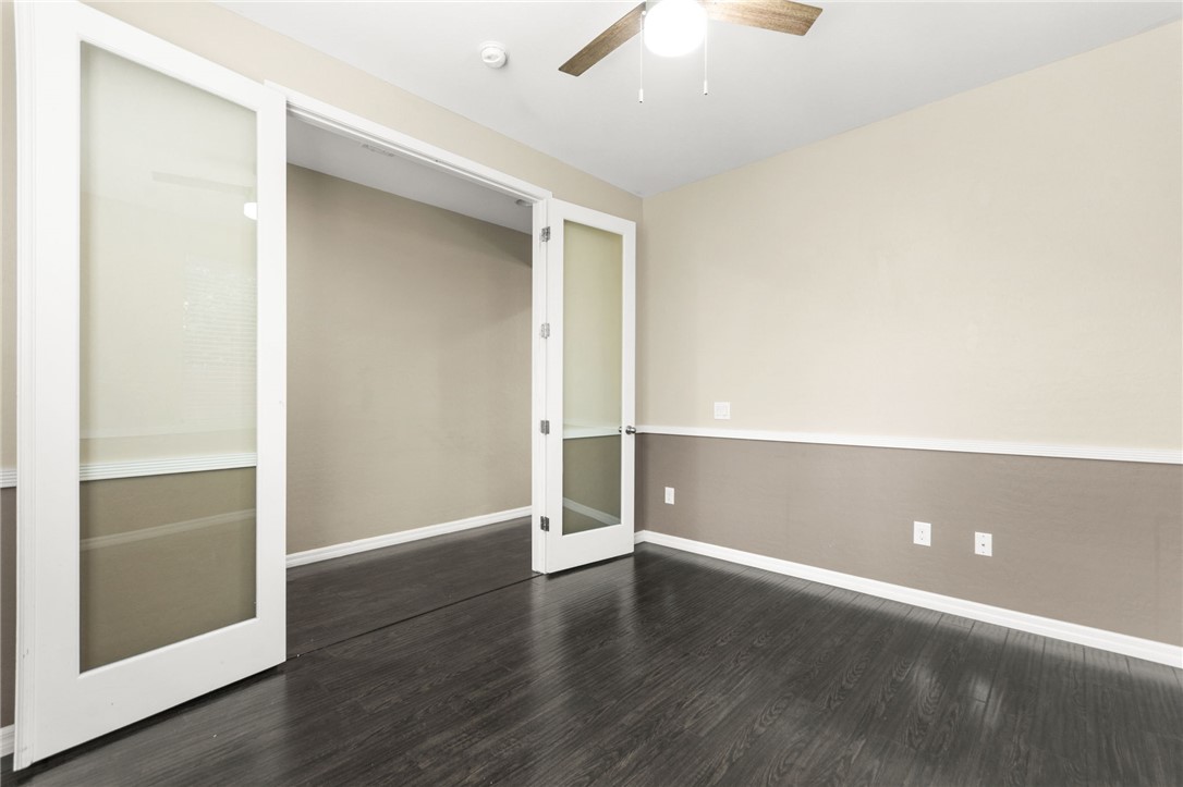 11048 Prairie Grove Road Las Vegas, NV 89179 - Photo 33 of 75 French doors open into a versatile space, featuring rich dark hardwood flooring and an overhead ceiling fan.