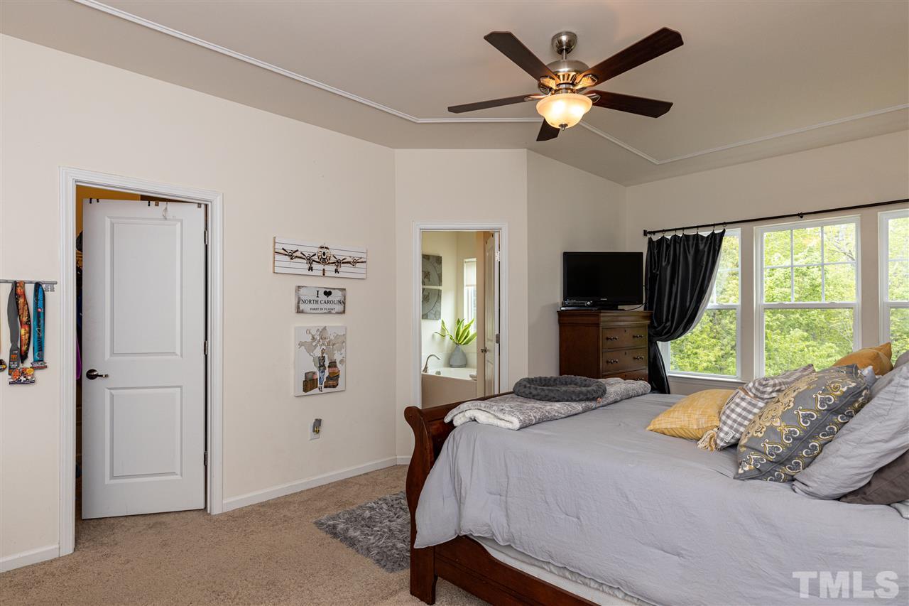 724 Edgewater Ridge Court Apex, NC 27523 - Photo 14 of 30 a bedroom with a large bed and a large window