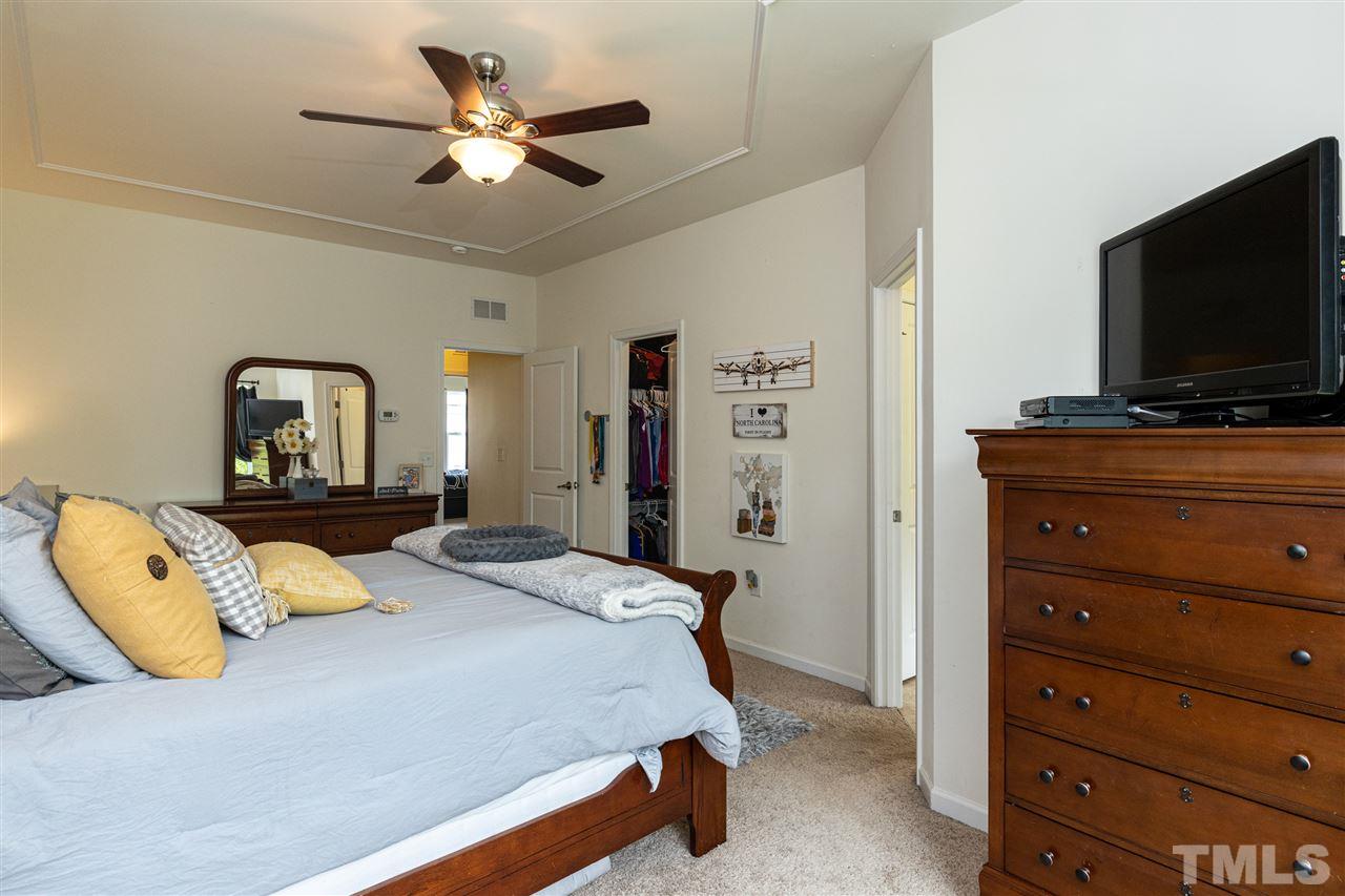 724 Edgewater Ridge Court Apex, NC 27523 - Photo 15 of 30 a bedroom with a bed and a flat screen tv