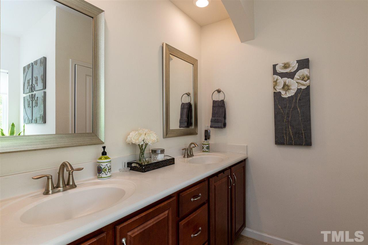 724 Edgewater Ridge Court Apex, NC 27523 - Photo 17 of 30 a bathroom with a double vanity sink and a mirror