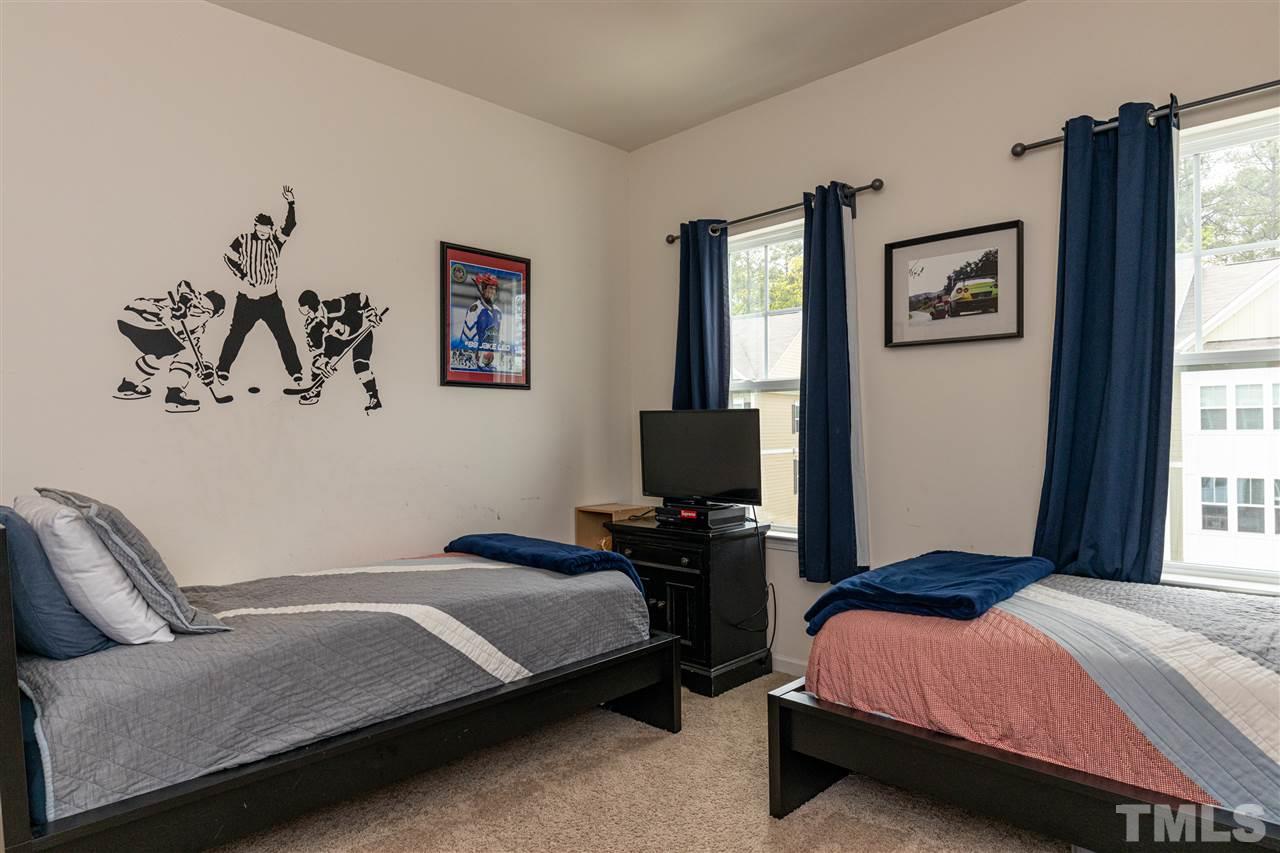 724 Edgewater Ridge Court Apex, NC 27523 - Photo 18 of 30 a bedroom with a bed and a flat screen tv