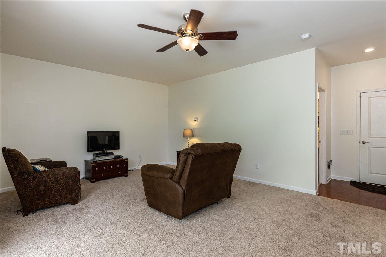 724 Edgewater Ridge Court Apex, NC 27523 - Photo 23 of 30 a living room with furniture and a flat screen tv