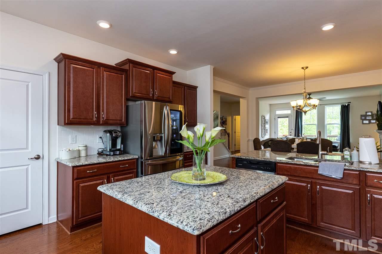 724 Edgewater Ridge Court Apex, NC 27523 - Photo 4 of 30 a kitchen with stainless steel appliances granite countertop wooden cabinets a sink and dishwasher