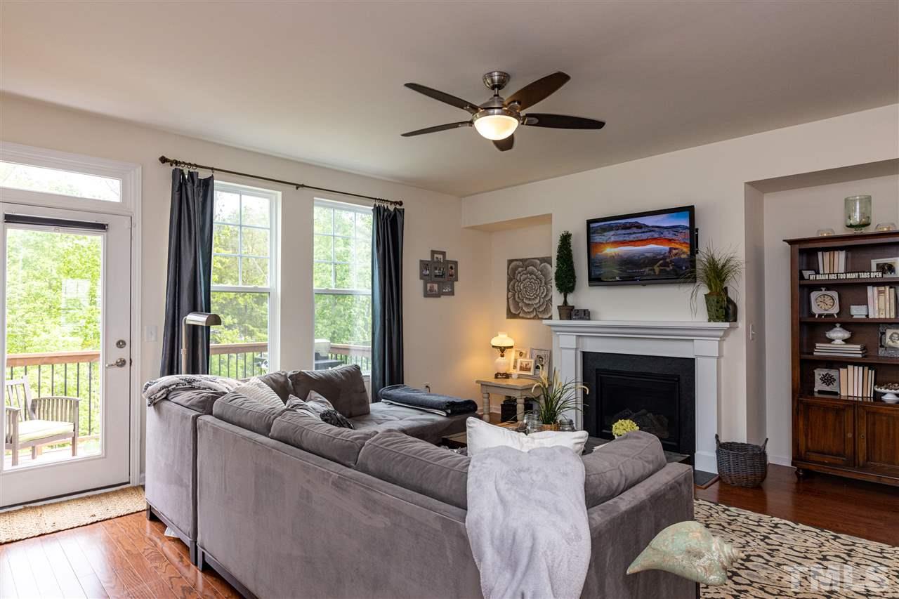 724 Edgewater Ridge Court Apex, NC 27523 - Photo 6 of 30 a living room with furniture fireplace and a flat screen tv
