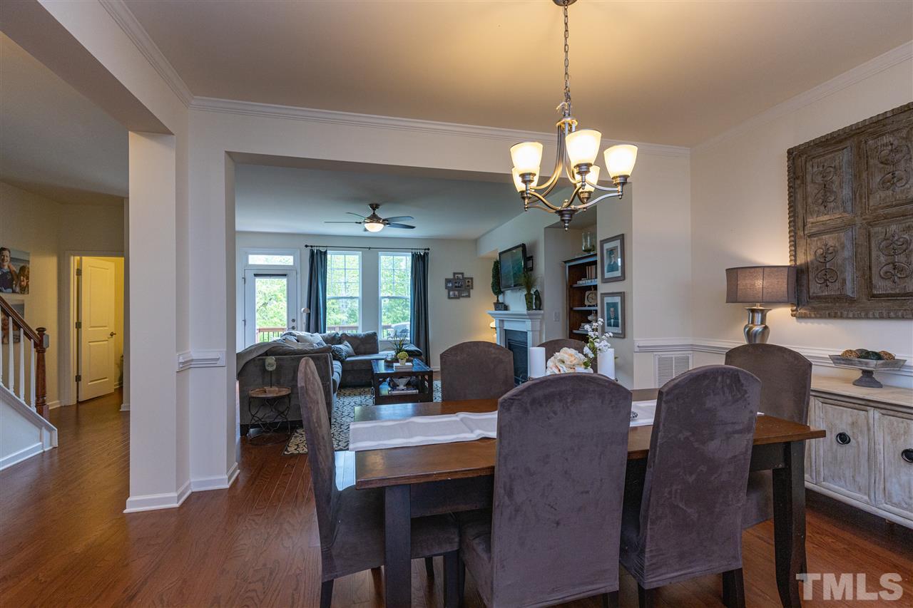 724 Edgewater Ridge Court Apex, NC 27523 - Photo 8 of 30 a view of a dining room with furniture and wooden floor