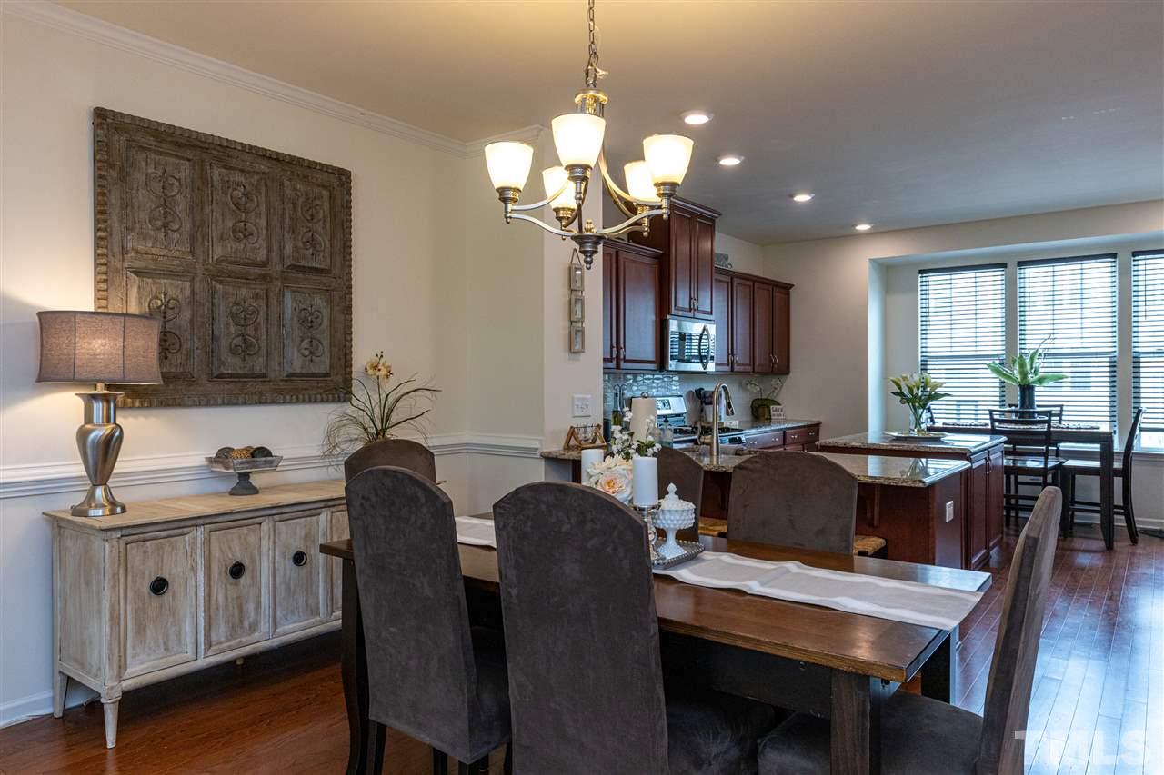 724 Edgewater Ridge Court Apex, NC 27523 - Photo 9 of 30 a view of a dining room with furniture and wooden floor