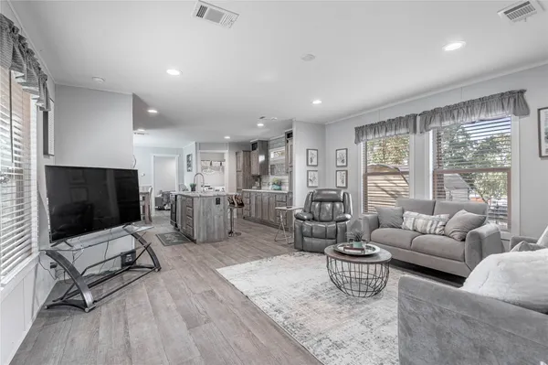 a living room with furniture flat screen tv and large window