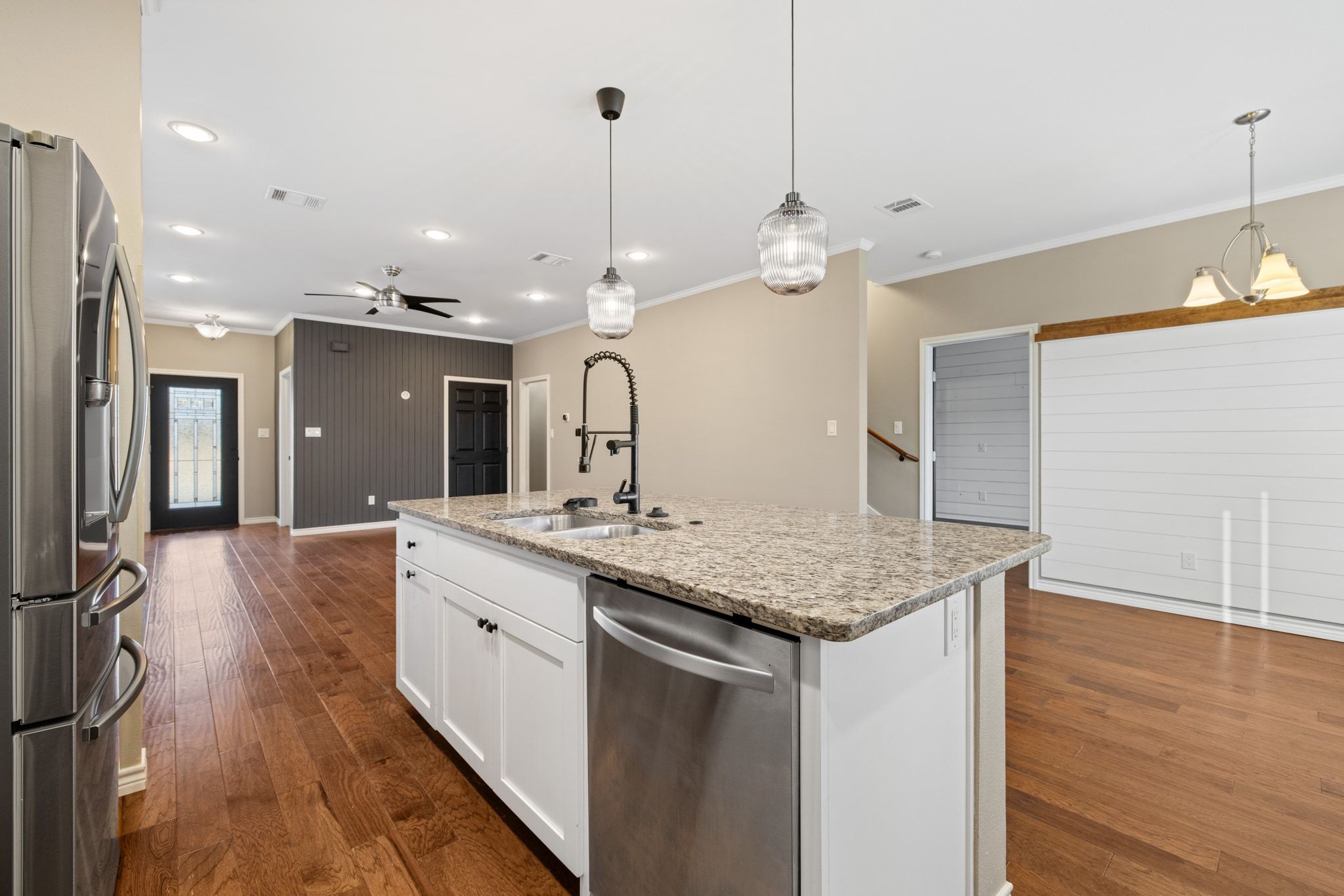 609 A West 7th Street Taylor, TX 76574 - Photo 35 of 35 Kitchen with stainless steel appliances, crown molding, light stone countertops, white cabinets, and open floor plan