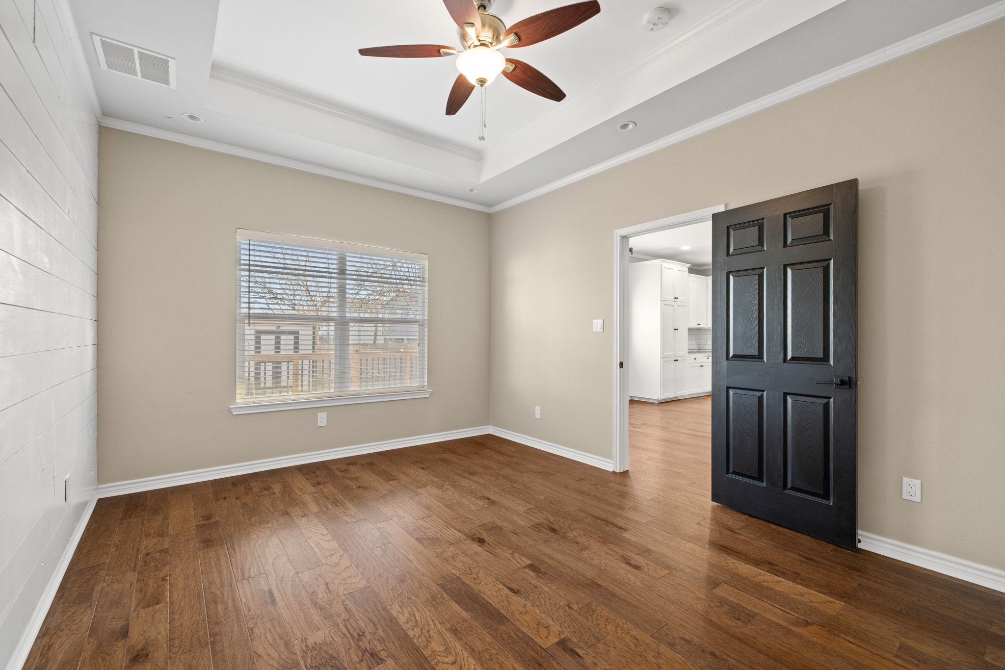 609 A West 7th Street Taylor, TX 76574 - Photo 12 of 35 an empty room with wooden floor chandelier fan and windows
