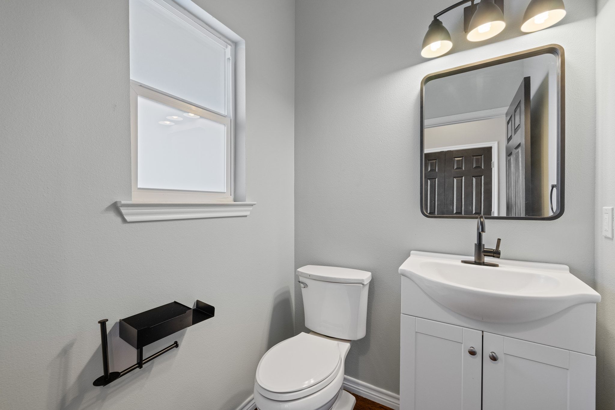609 A West 7th Street Taylor, TX 76574 - Photo 20 of 35 a bathroom with a toilet a sink a vanity and mirror