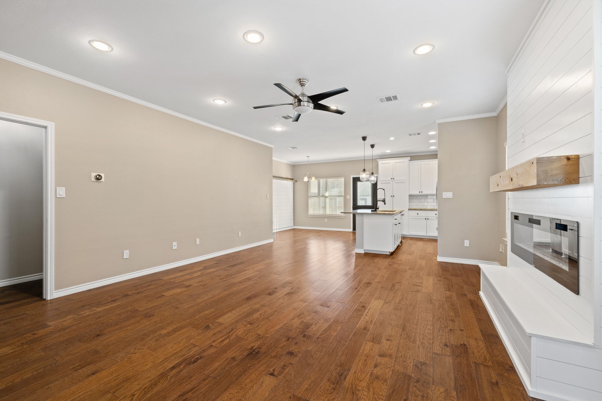 609 A West 7th Street Taylor, TX 76574 - Photo 8 of 35 Unfurnished living room with ceiling fan, ornamental molding, dark wood-style flooring, and recessed lighting