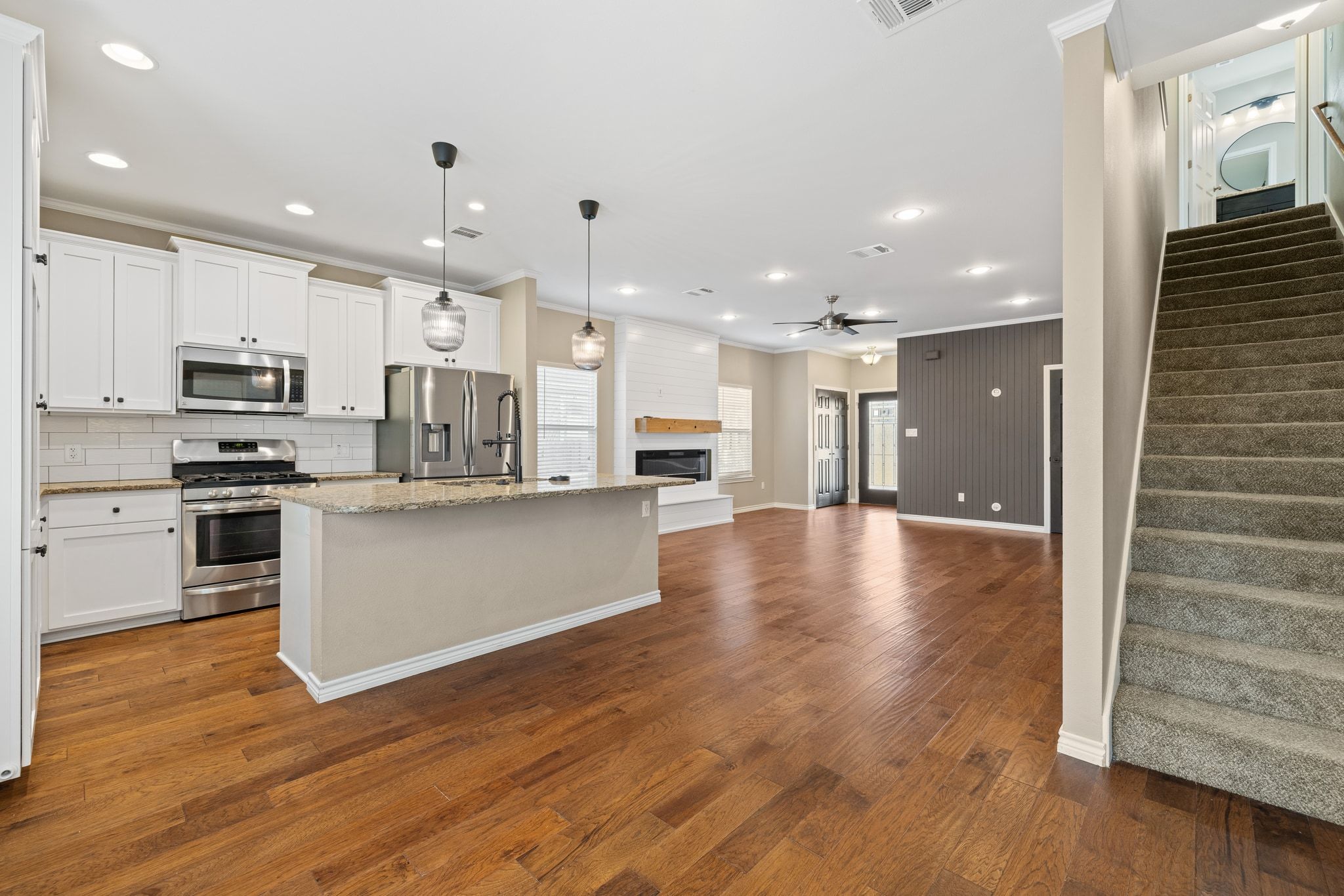 609 A West 7th Street Taylor, TX 76574 - Photo 34 of 35 Kitchen with open floor plan, a center island with sink, stainless steel appliances, pendant lighting, and white cabinetry
