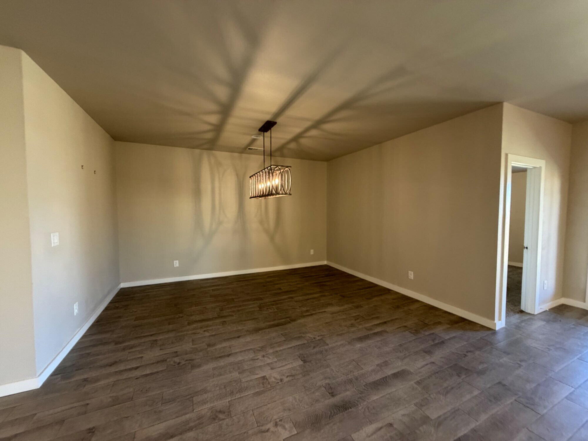 328 Ranger Street Wolfforth, TX 79382 - Photo 5 of 15 a view of an empty room with wooden floor and a window