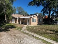 a front view of a house with a yard and potted plants