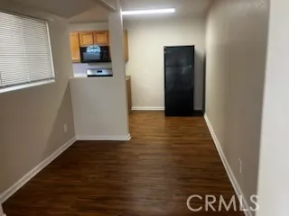 a view of a hallway with wooden floor and a flat screen tv