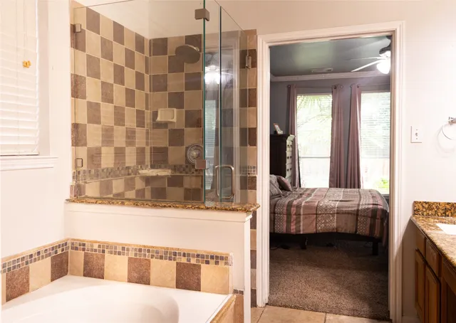 a bed sitting in a bedroom next to a window and a chair