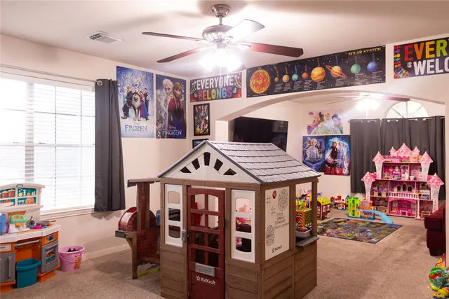en empty room with windows and ceiling fan