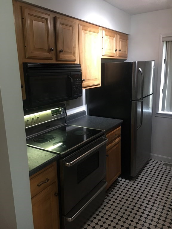 40 Hunters Run Place, Unit 40 Haverhill, MA 01832 - Photo 6 of 13 a kitchen with granite countertop a refrigerator stove and microwave