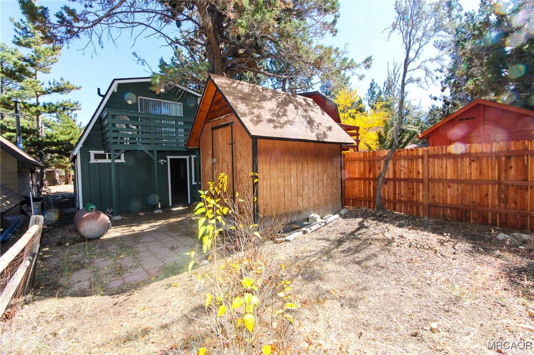 692 San Bernardino Avenue Sugarloaf, CA 92386 - Photo 20 of 20 a backyard of a house with table and chairs under an umbrella