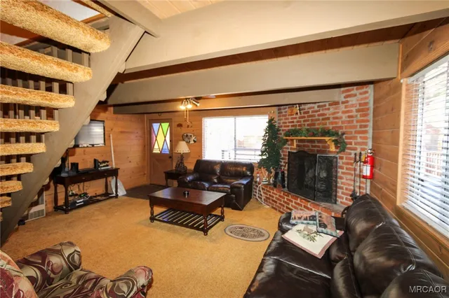a living room with furniture fireplace and a large window