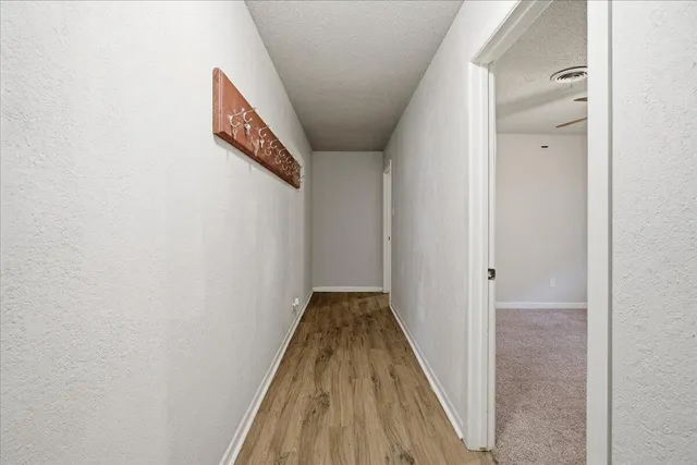 a view of a hallway with wooden floor