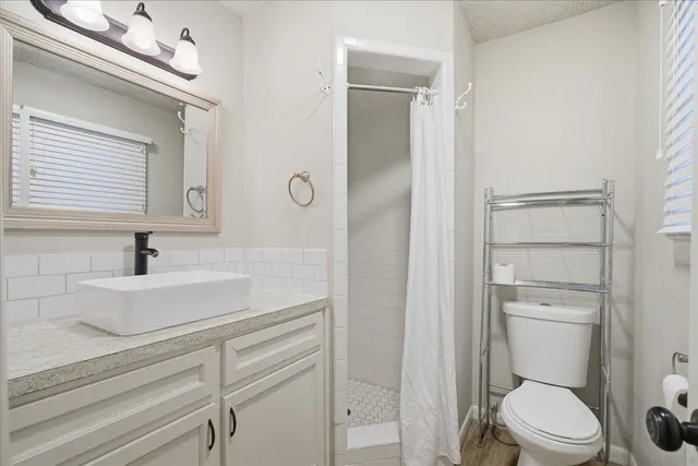 a bathroom with a toilet a sink and mirror