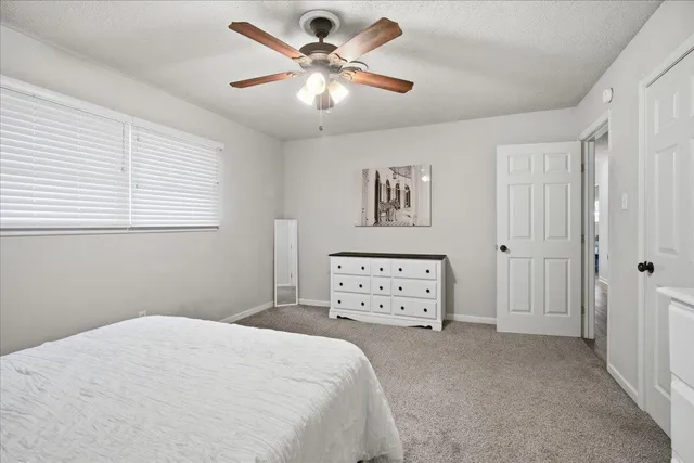 a bedroom with a bed a chandelier and a window