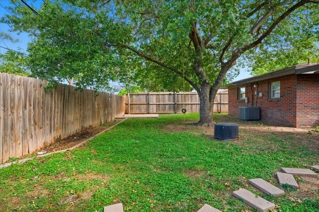 a view of a house with backyard and a tree