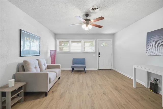 a living room with furniture and a wooden floor