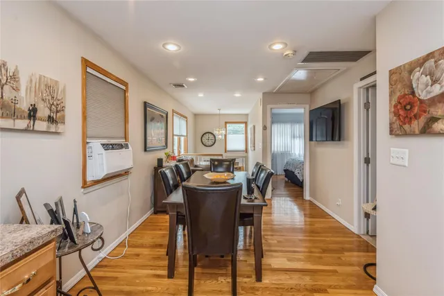 a view of a dining room with furniture a rug and wooden floor