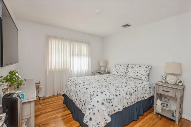 a bedroom with a bed and a potted plant