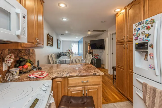 a kitchen with stainless steel appliances granite countertop a refrigerator and a stove