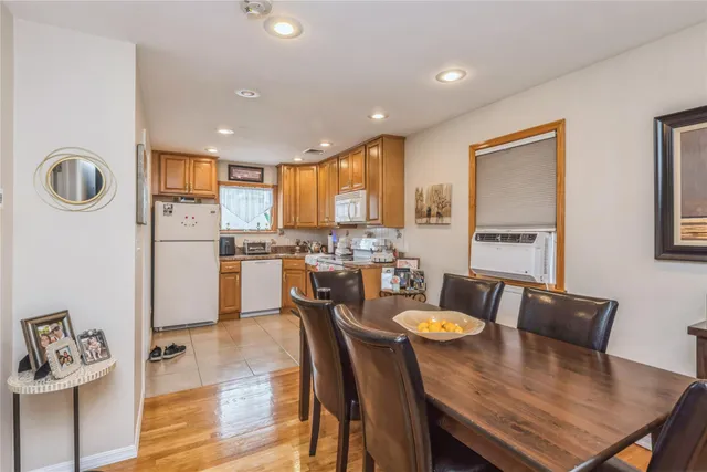 a kitchen with stainless steel appliances granite countertop a stove a refrigerator a dining table and chairs