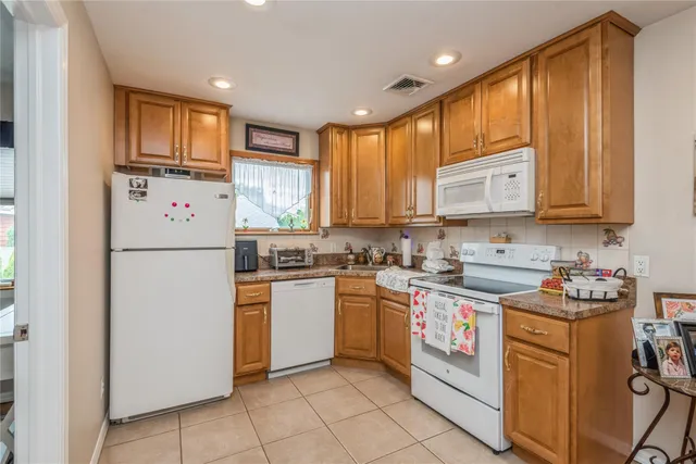 a kitchen with stainless steel appliances granite countertop a refrigerator sink and stove