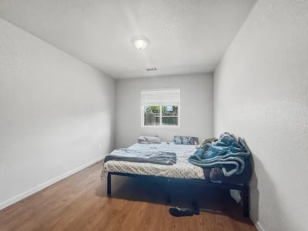 a bedroom with a bed and wooden floor
