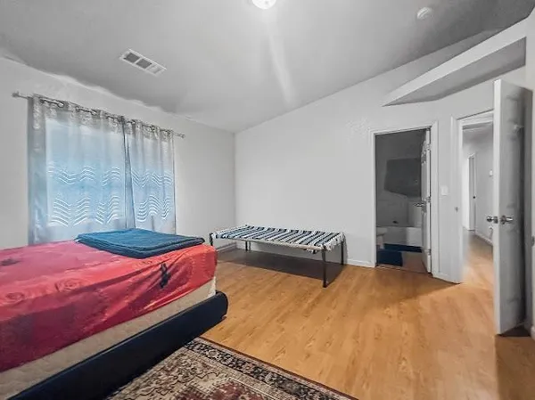 a bedroom with a bed and wooden floor