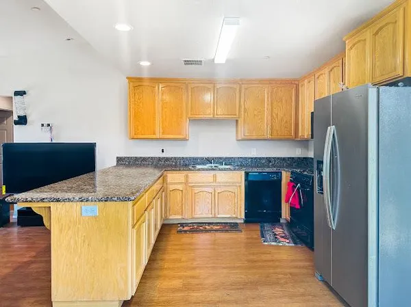 a kitchen with stainless steel appliances granite countertop a refrigerator and a sink