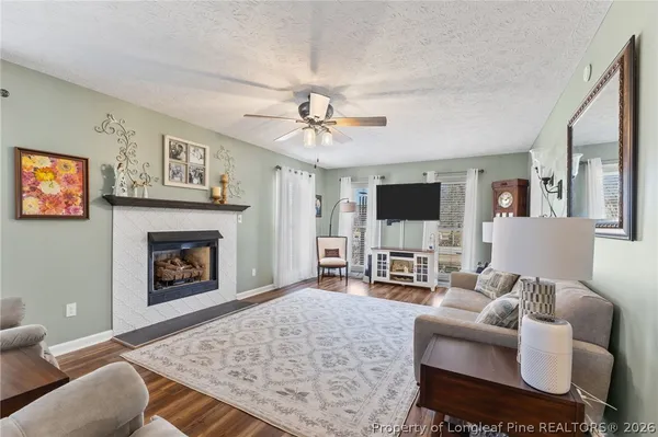 a living room with furniture a flat screen tv and a fireplace