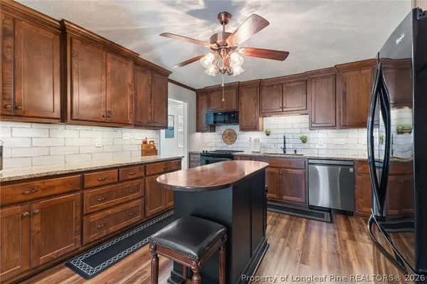 a kitchen with granite countertop a sink appliances cabinets and furniture