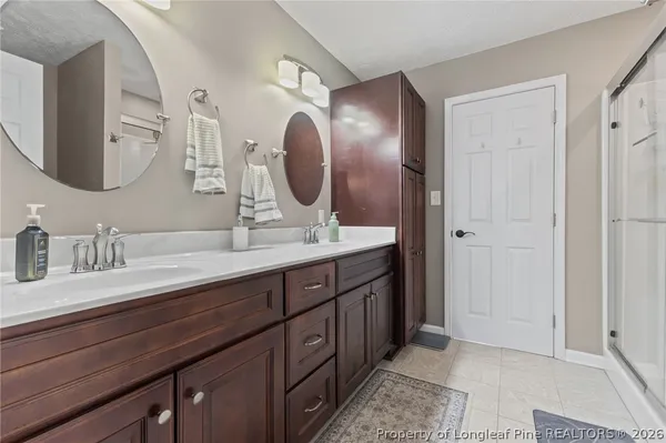 a bathroom with double vanity and a mirror