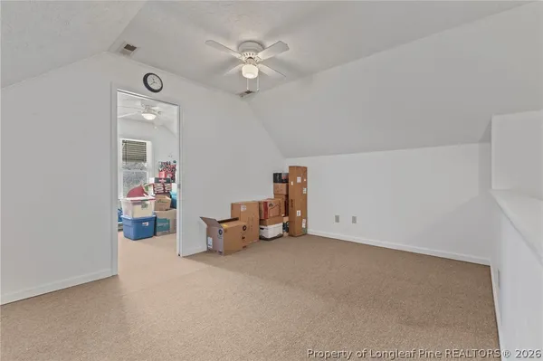 a spacious bedroom with a bed a desk and chair