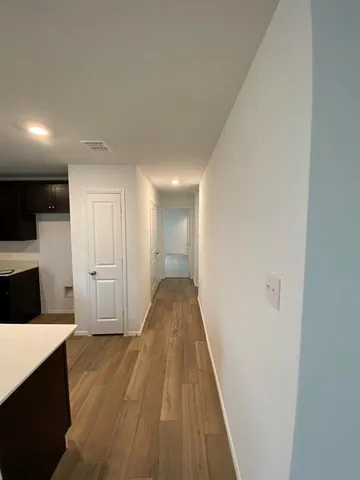 a view of a hallway with wooden floor and staircase