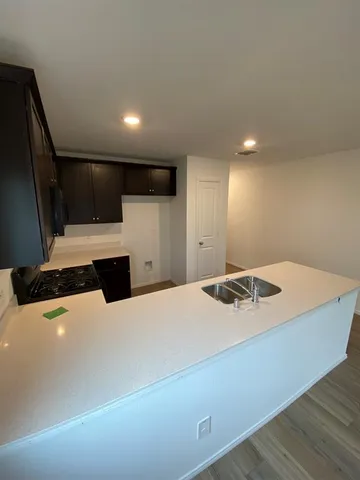 a kitchen with stainless steel appliances a kitchen island hardwood floor sink stove dining table and chairs