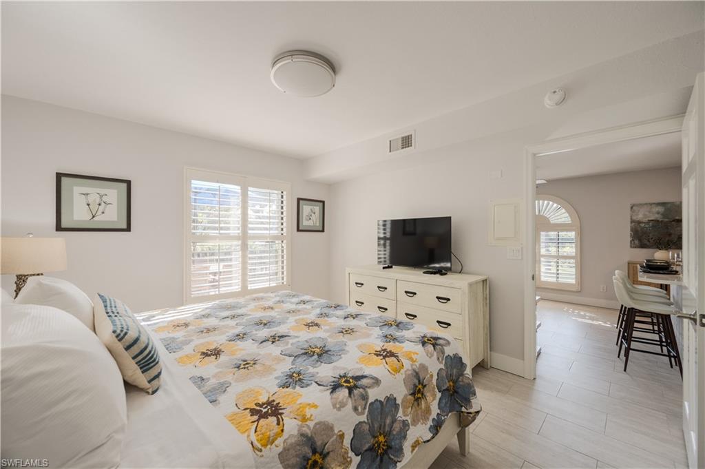 655 8th Avenue South, Unit 3 Naples, FL 34102 - Photo 11 of 48 a bedroom with a bed and a flat screen tv