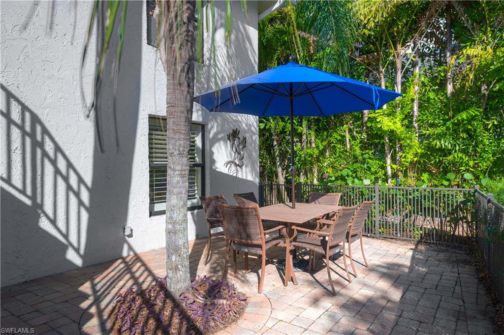 655 8th Avenue South, Unit 3 Naples, FL 34102 - Photo 18 of 48 a view of a patio with table and chairs under an umbrella