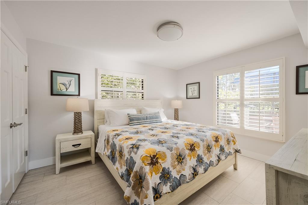 655 8th Avenue South, Unit 3 Naples, FL 34102 - Photo 23 of 48 a bedroom with a bed a wall painting and a window