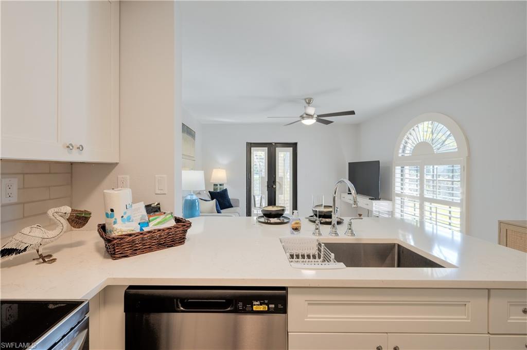 655 8th Avenue South, Unit 3 Naples, FL 34102 - Photo 28 of 48 a kitchen with a sink dishwasher and white cabinets with wooden floor