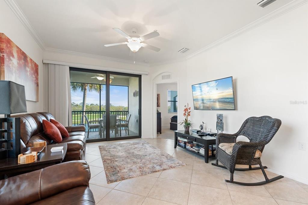 16904 Vardon Terrace, Unit 301 Lakewood Ranch, FL 34211 - Photo 11 of 28 a living room with furniture and a floor to ceiling window